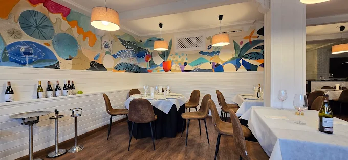 Salle intérieure avec une fresque colorée et tables dressées