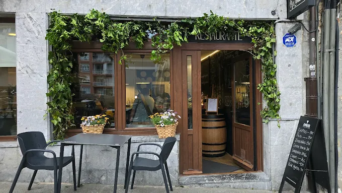 Façade de Chispa y Leña avec lierre et terrasse
